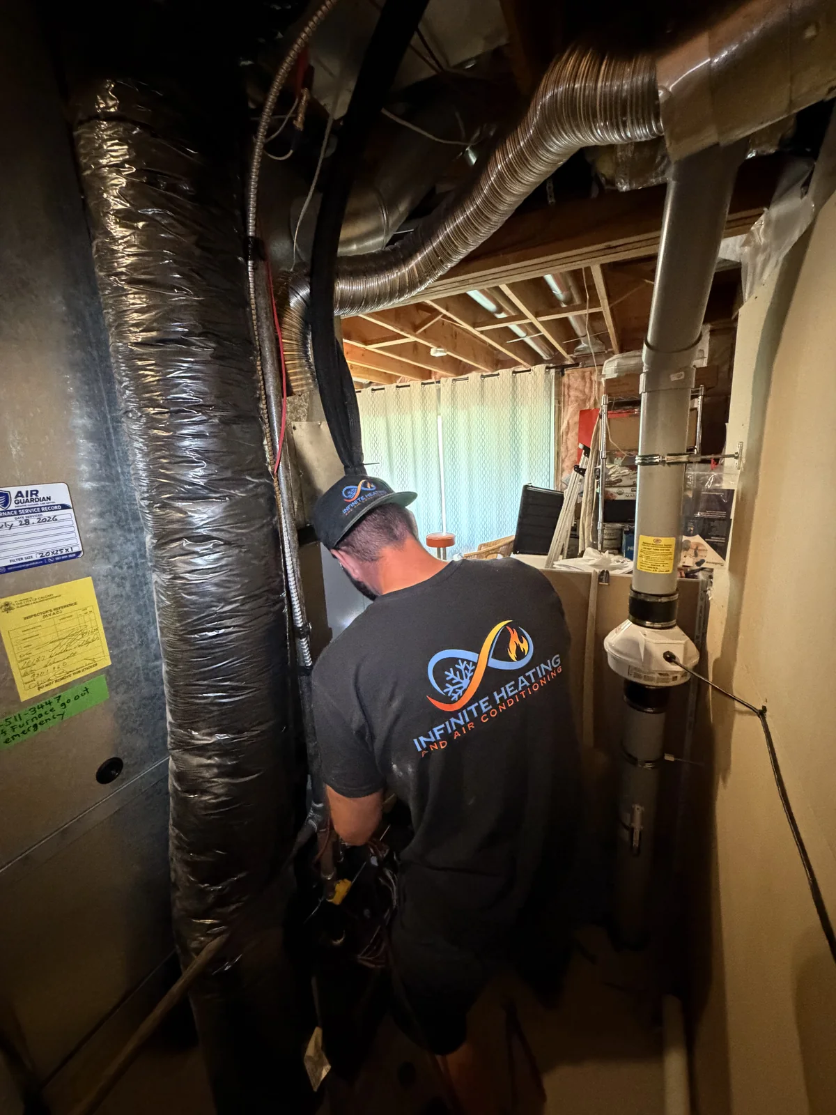 Infinite Heating technician performing furnace maintenance